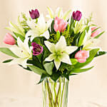 Medley Of Lilies And Tulips In Glass Vase