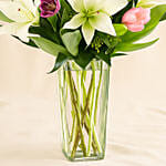 Medley Of Lilies And Tulips In Glass Vase